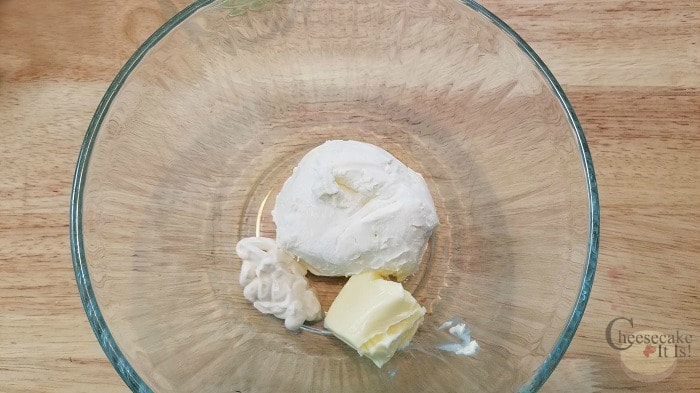 Cream cheese, sour cream and butter in glass bowl.