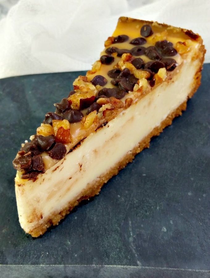 Slice of turtle cheesecake on slate.