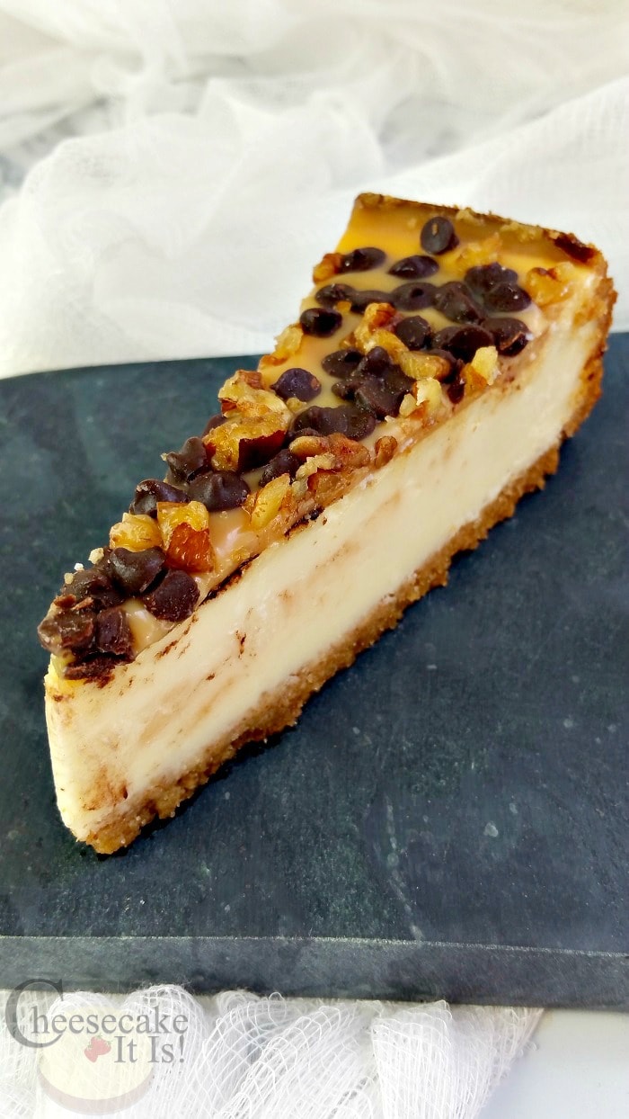 Slice of turtle cheesecake on slate.