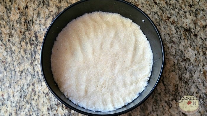 Coconut crust packed into a springform pan.