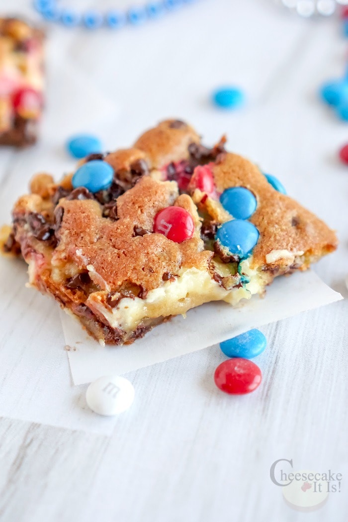 M&M Chocolate Chip Cheesecake Bars with red white and blue m&m's on top and around.