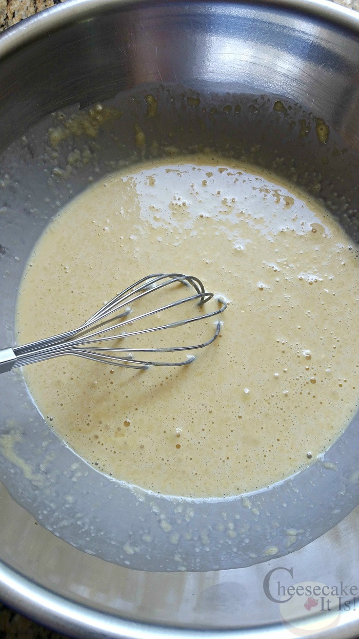 Eggs and cream mixed together in bowl with wisk.