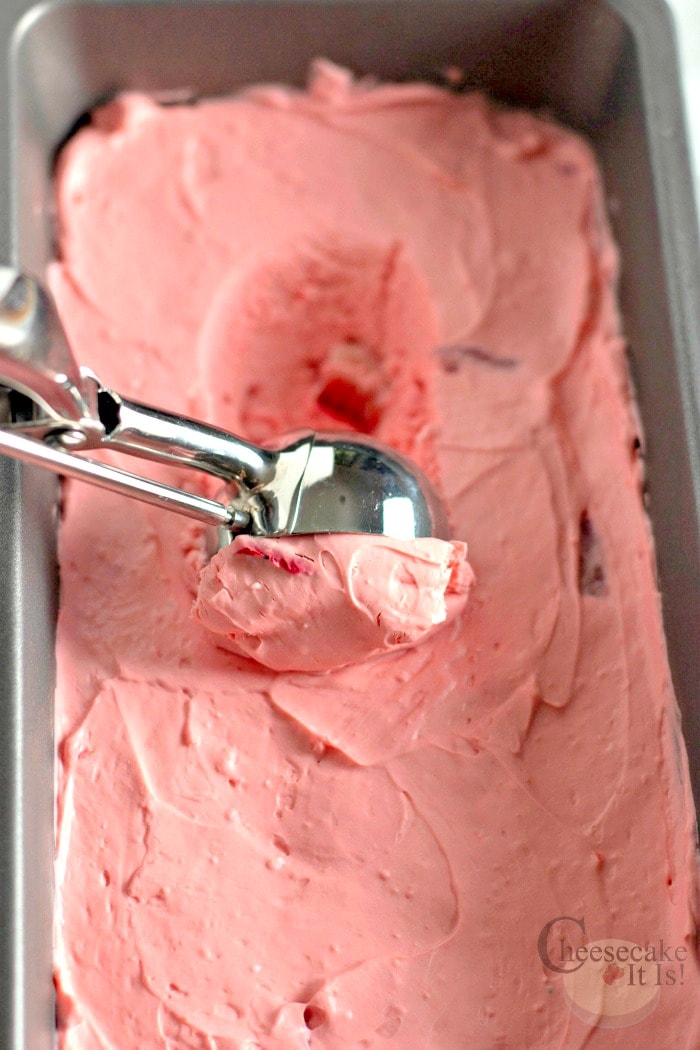 Ice cream scoop scooping a serving of strawberry cheesecake fluff from pan.