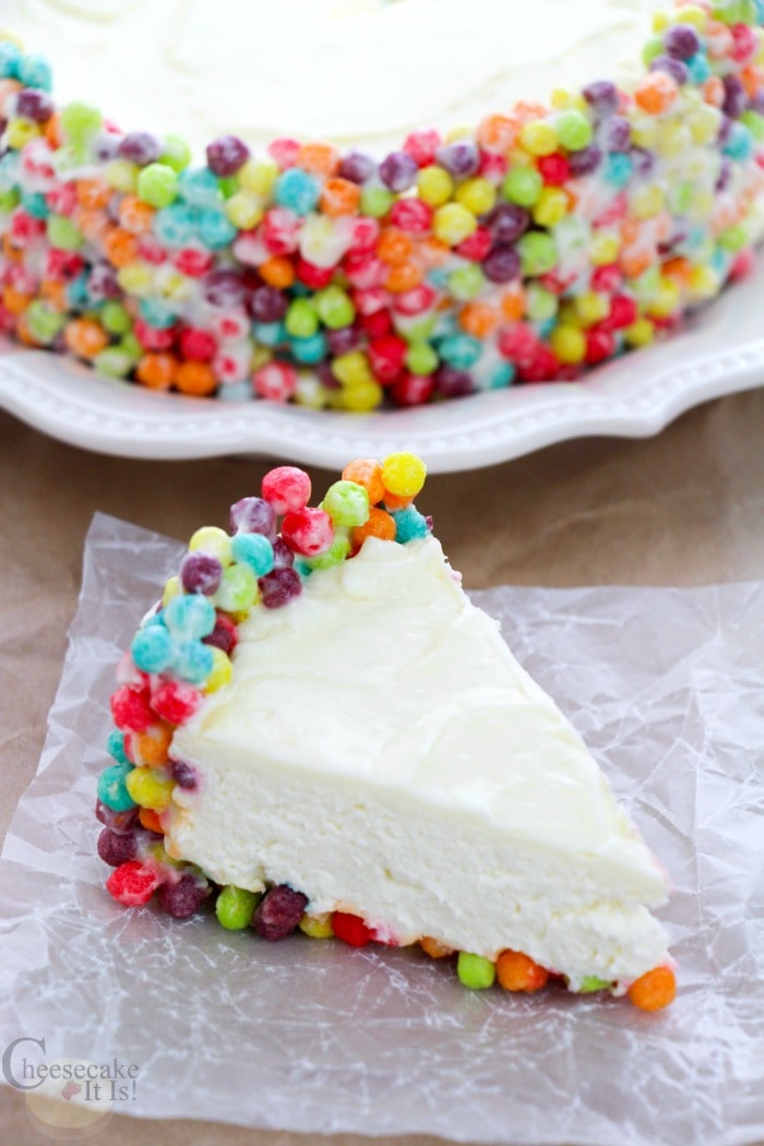 Slice of No-Bake Trix Cheesecake in the front and the rest of the cheesecake in the background.