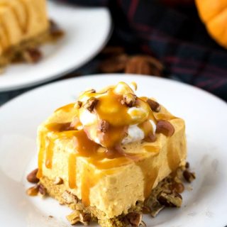 Slice of no bake pumpkin cheesecake on white plate with toppings