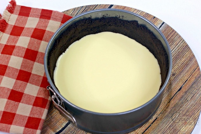 Cheesecake batter poured over crust