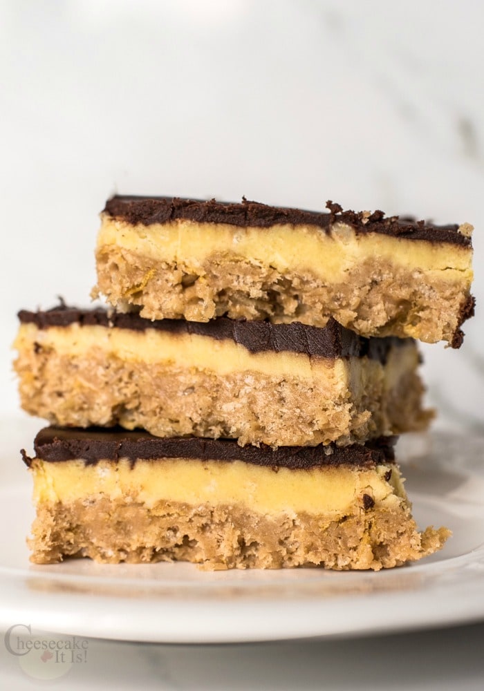 3 Peanut Butter & Chocolate Cheesecake Bars stacked on white plate