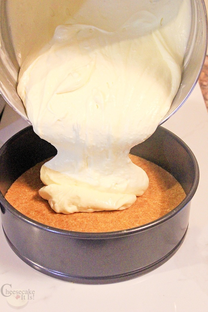 Pouring lemon cheesecake mix into pan with crust