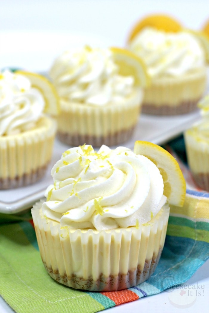 Lemon cheesecake minis in cupcake liners topped with whipped topping and lemon zest