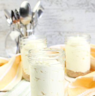 3 Keto no bake cheesecake recipe made in jars with jar of spoons in background