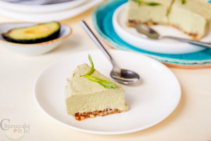 Slice of avocado cheesecake on white plate