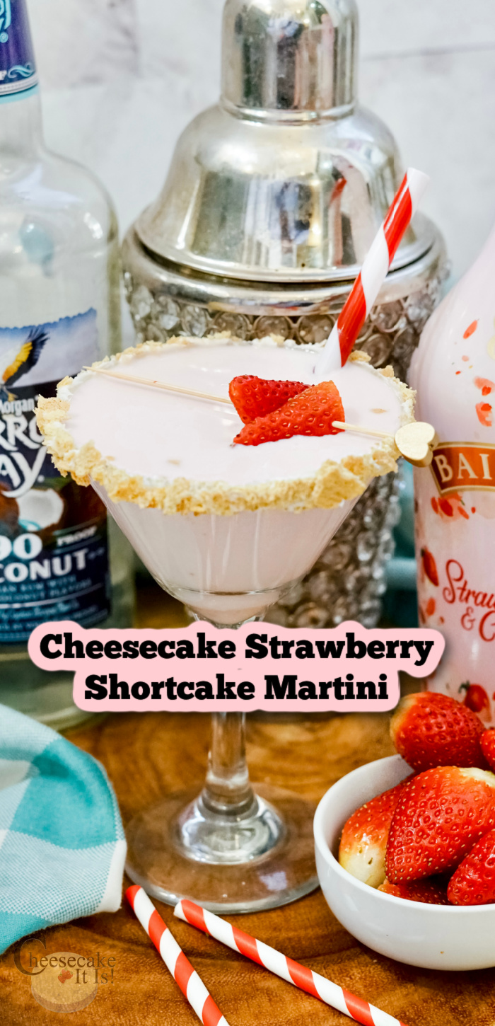 Full glass of strawberry shortcake martini with coconut rum and Baileys strawberries and cream behind. Text overlay in middle that says Cheesecake Strawberry Shortcake Martini