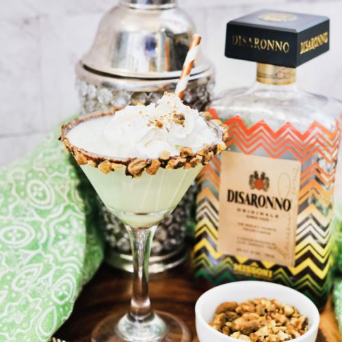 Glass or pistachio martini recipe with shaker and bottle to back and side