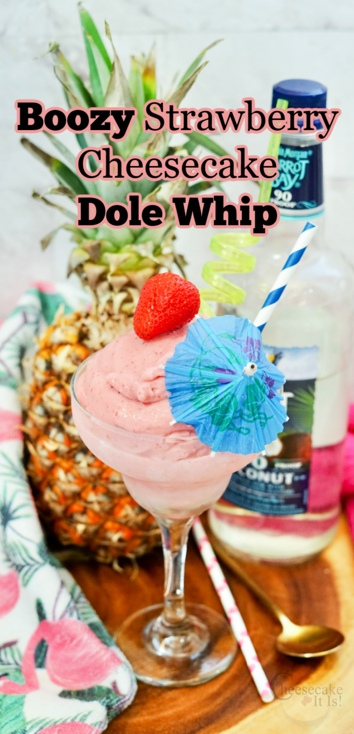 Glass full of strawberry cheesecake dole whip with strawberry and umbrella on top. Text overlay at top that says Boozy Strawberry Cheesecake Dole Whip Recipe