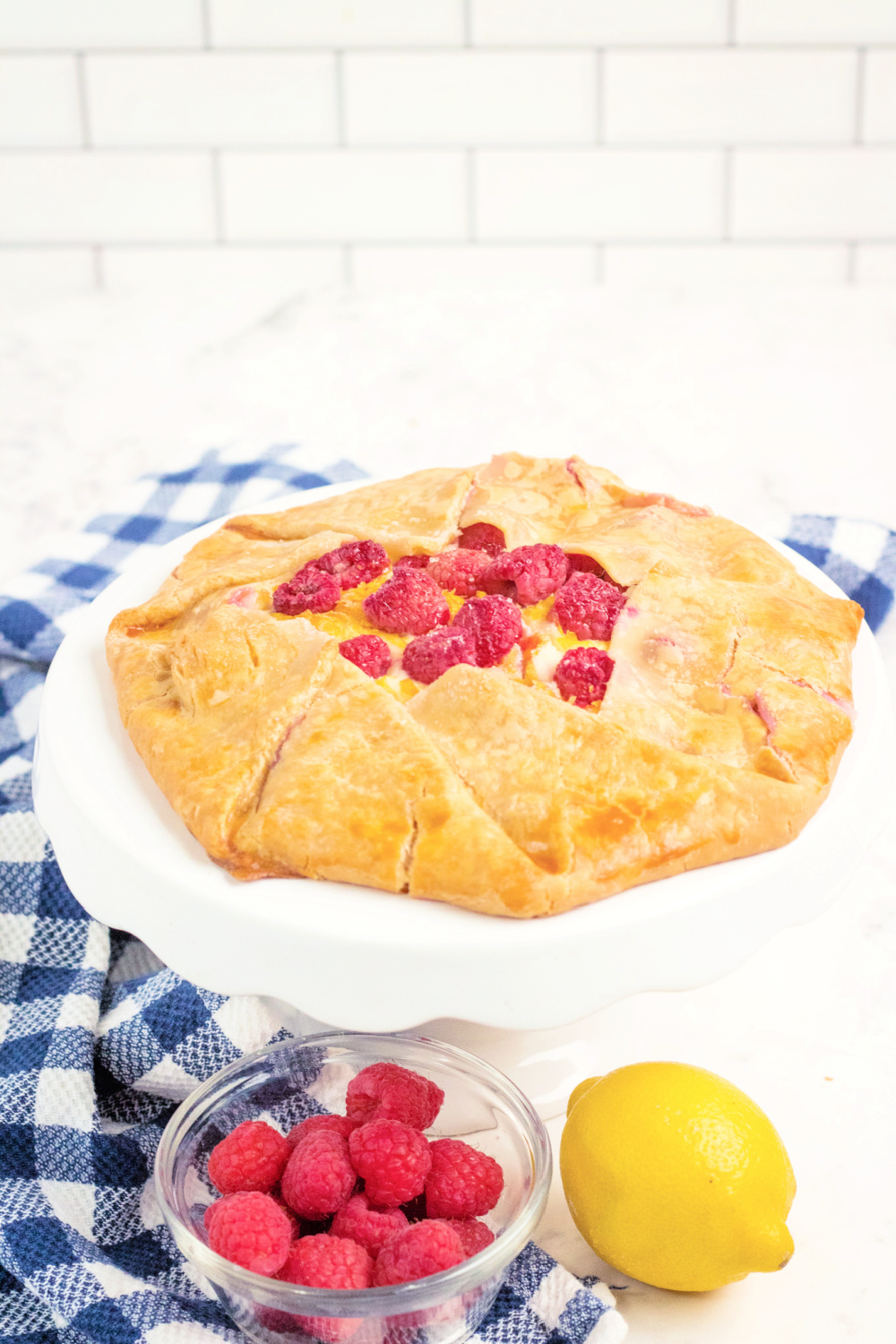 Whole cheesecake raspberry galette on white cake stand