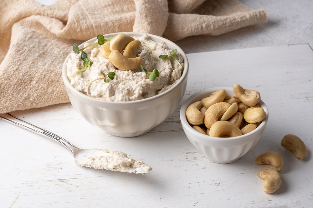 Bowl of Cashew Cheese with cashews beside it