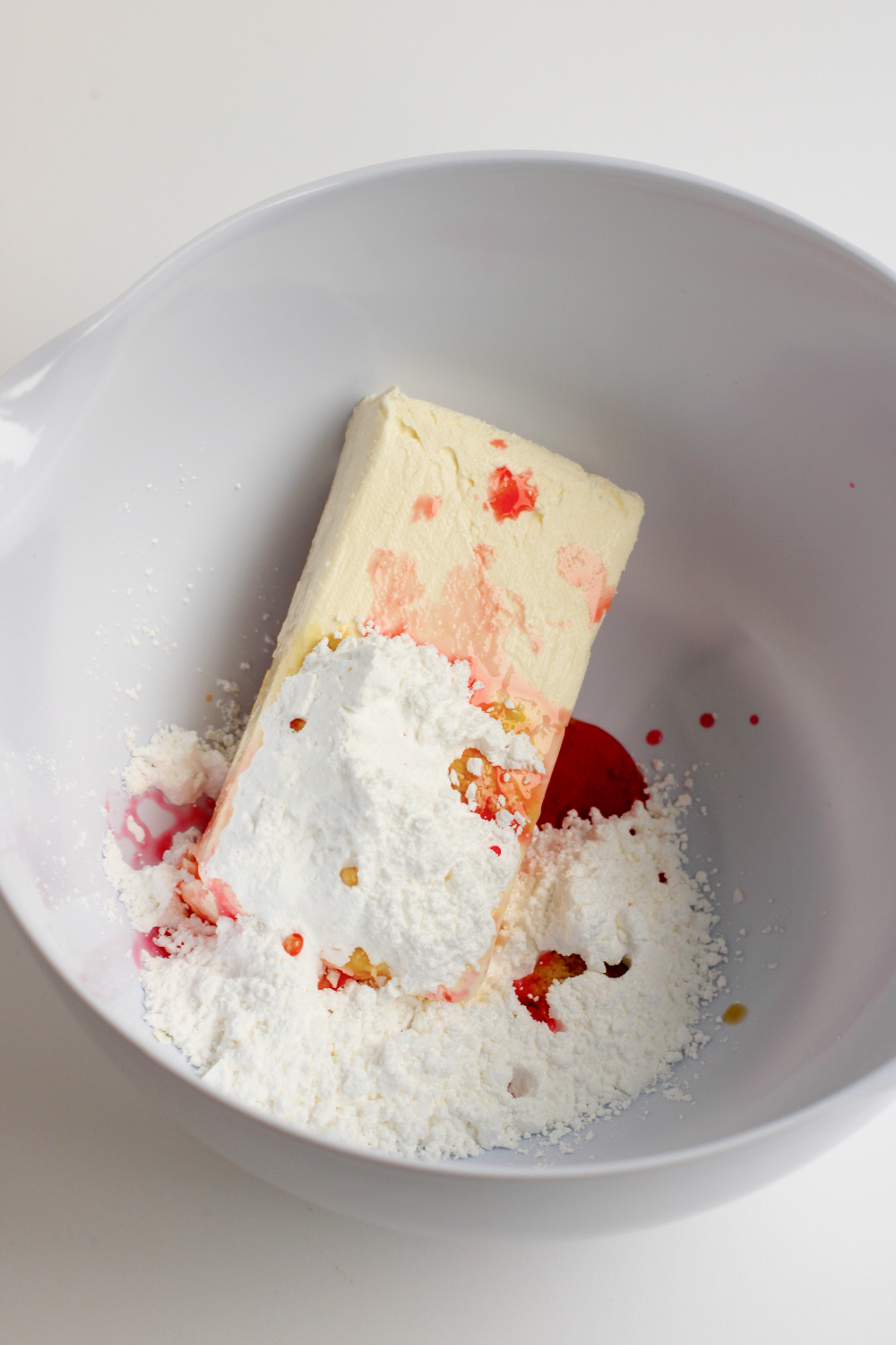 Cream cheese sugar and cherry juice in bowl
